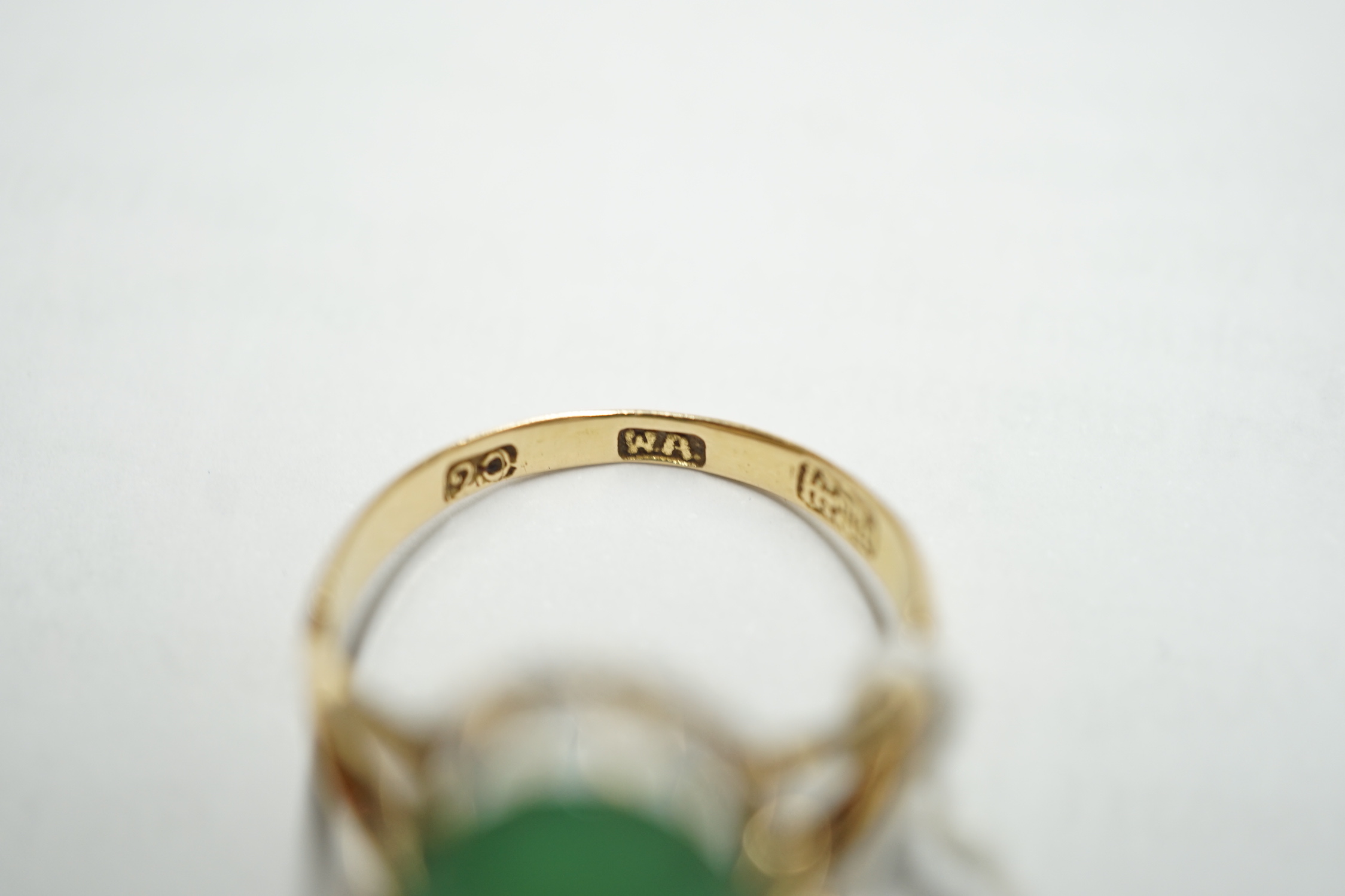 A Chinese yellow metal and cabochon jade set oval ring, size Q/R, gross weight 5 grams.